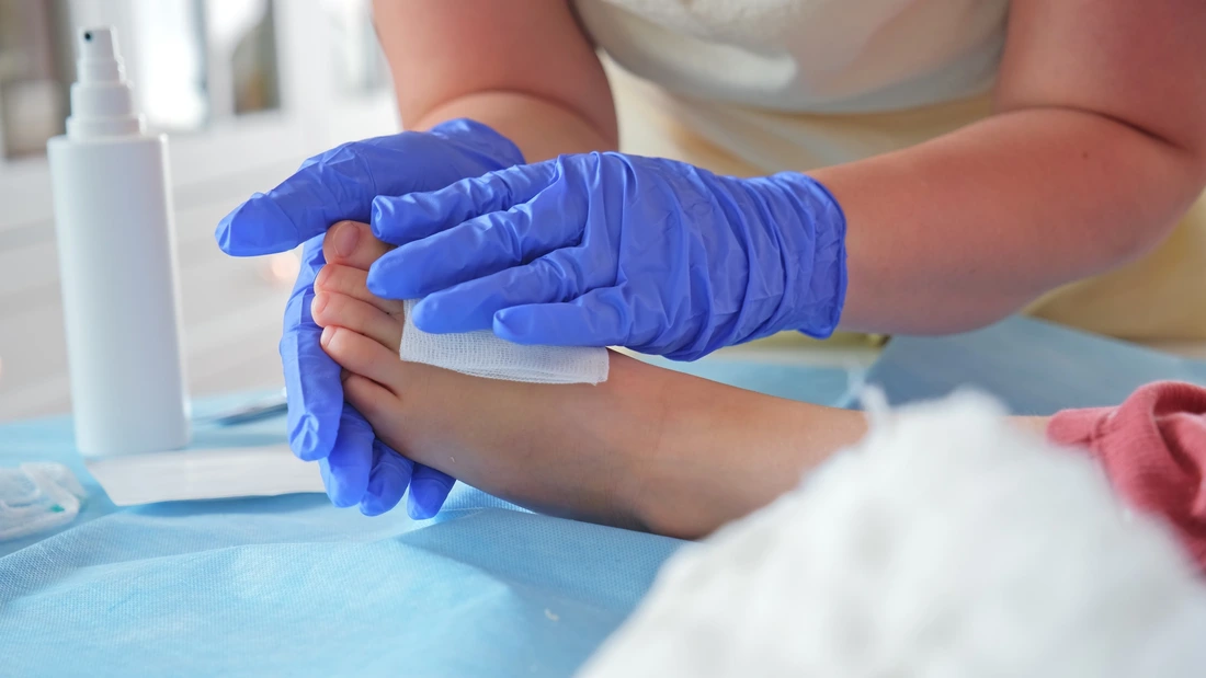 Registered Nurse Pediatritian Surgeon Doctor Treating Feet Injury Wound during Medical Procedure on Young Caucasian Girl Patient
