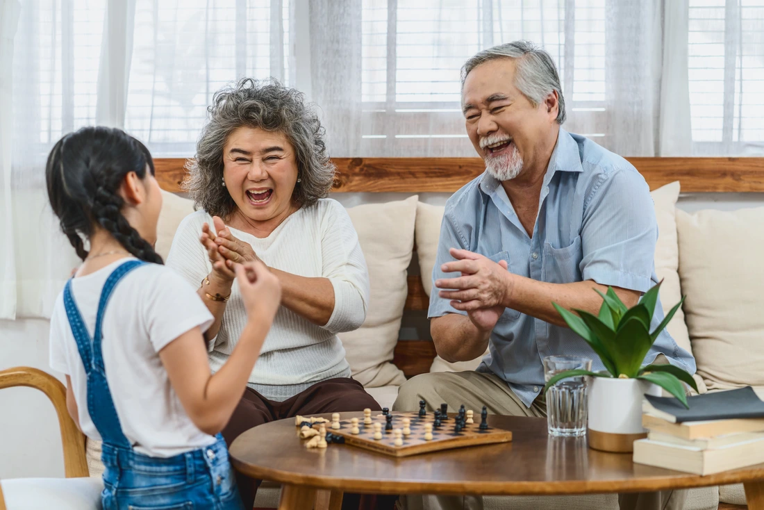 Asian couple Grandparent with grandchild playing the chess with happy feeling together, celebrating and winning, Long live and Elderly society,Warm family and happiness,social distancing concept