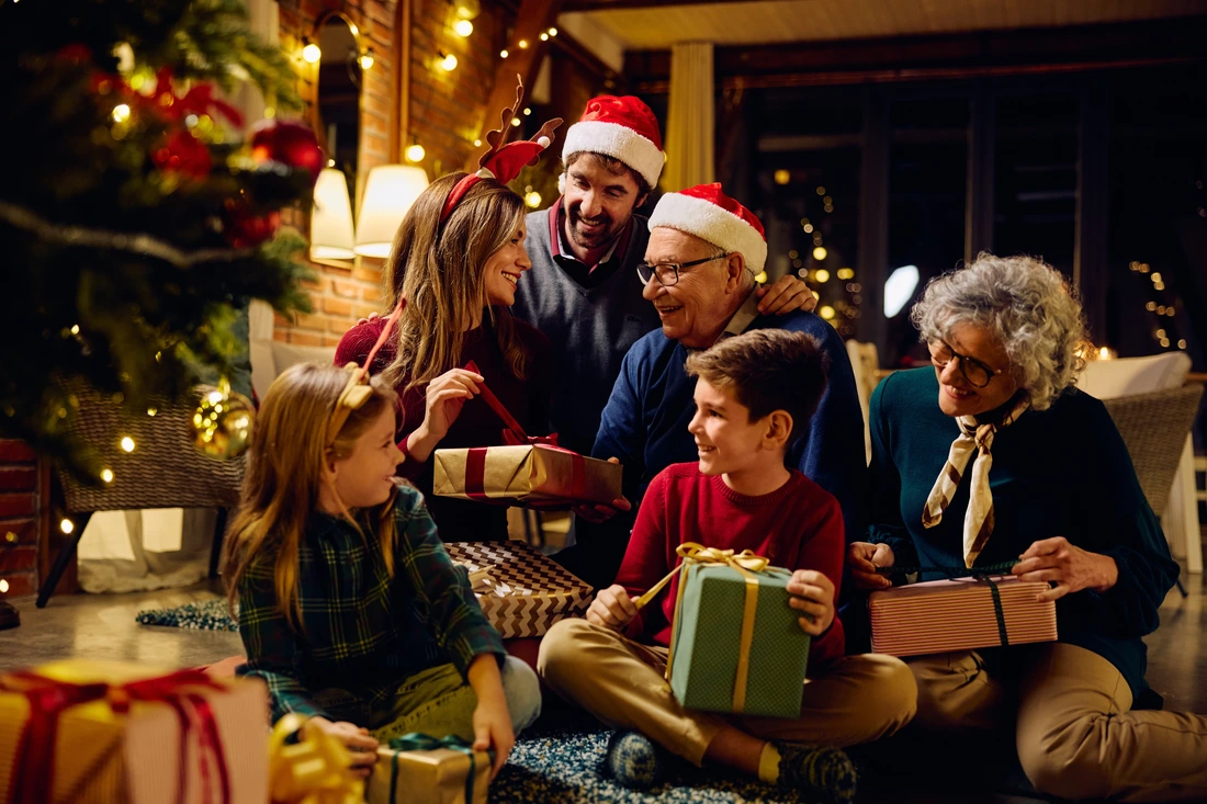 Happy multigeneration family enjoying in opening gifts on Christmas eve at home