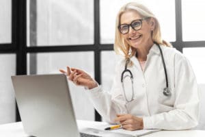 Female doctor smiling at laptop