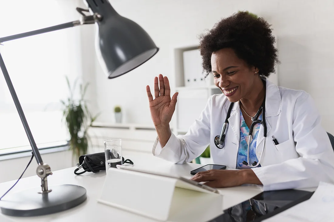 African American woman doctor working at her office online using portable inormation device Telemedicine services Primary care consultations, psychotherapy, emergency services