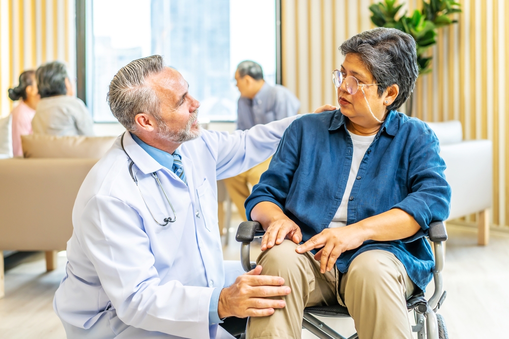 Professional doctor talk and encourage to elderly woman hand who sitting on the wheelchair at hospital, Caregiver provide care medical service help support smiling old grandma at home care medical